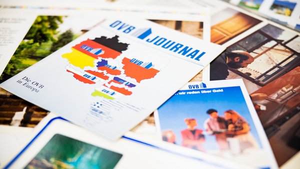 Niekoľko historických vydaní časopisu OVB leží na stole jedno na druhom.