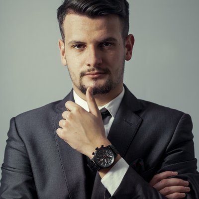 Muž v saku s hodinkami a gestom