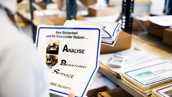 Osoba drží v rukách výtlačok poradenskej stratégie ABS.