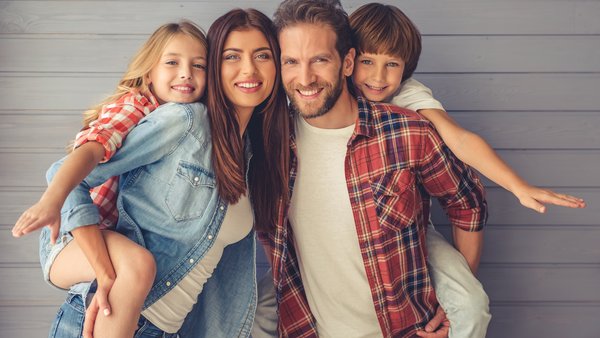 Šťastná rodina pózuje spolu pred stenou