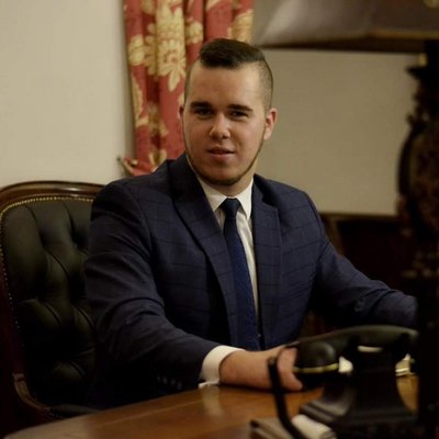 Mladý muž v saku pri stole