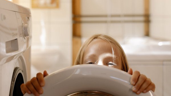 Dievča pred práčkou – zníž náklady na energiu
