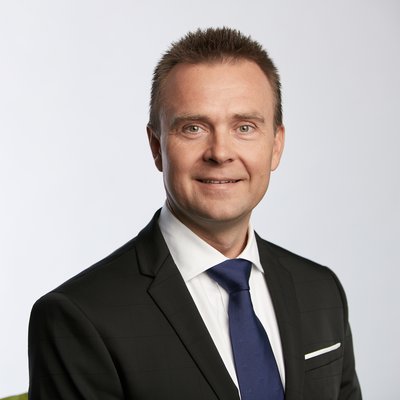 Muž v čiernom obleku s modrou kravatou