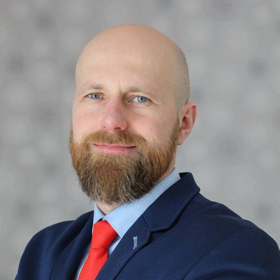 Plešatý muž s bradou v obleku