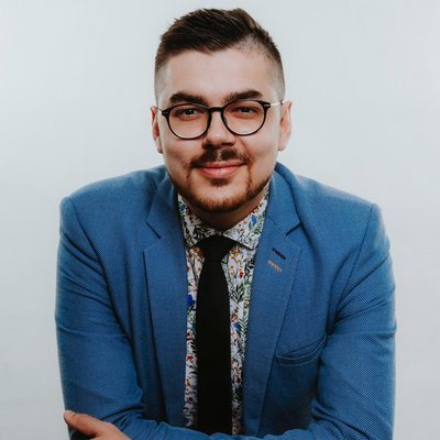 Usmiaty muž v modrom sako s okuliarmi