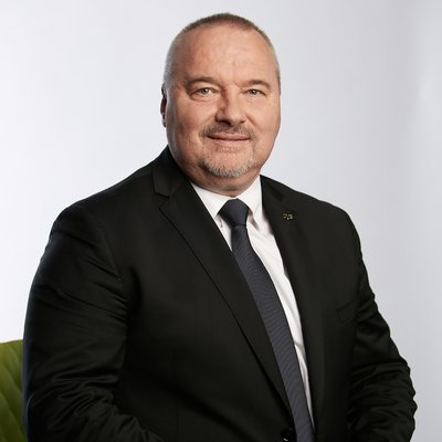 Muž v čiernom obleku s odznakom