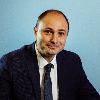 Muž v obleku pred modrým pozadím