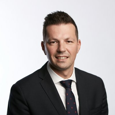 Muž s tmavými vlasmi a kravatou