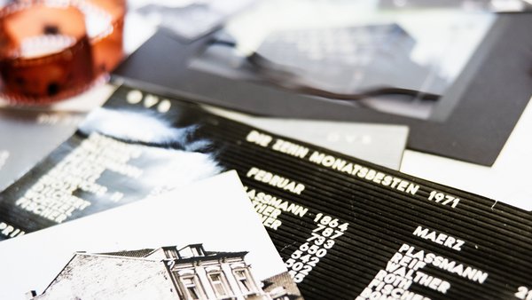 Historické fotografie budovy OVB ležia na stole, pod ním sú ďalšie dokumenty