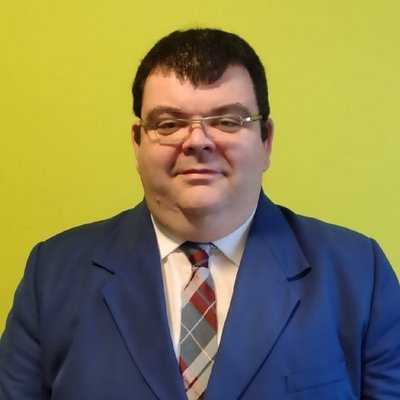 Biznismen v modrom obleku pred žltým pozadím