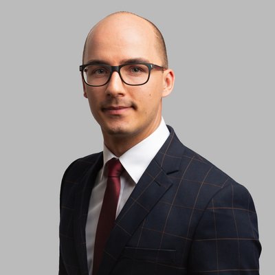 Muž v okuliaroch s červenou kravatou