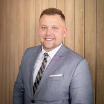 Usmiaty muž v obleku pri stene