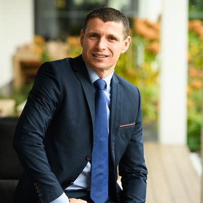 Muž v obleku sedí na terase kancelárie