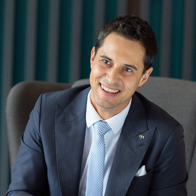 Muž v obleku a s kravatou v šedom kresle