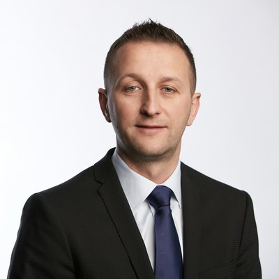 Muž v obleku a modrej kravate na bielom pozadí