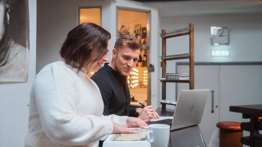 Kolegovia diskutujú nad dokumentom a notebookom