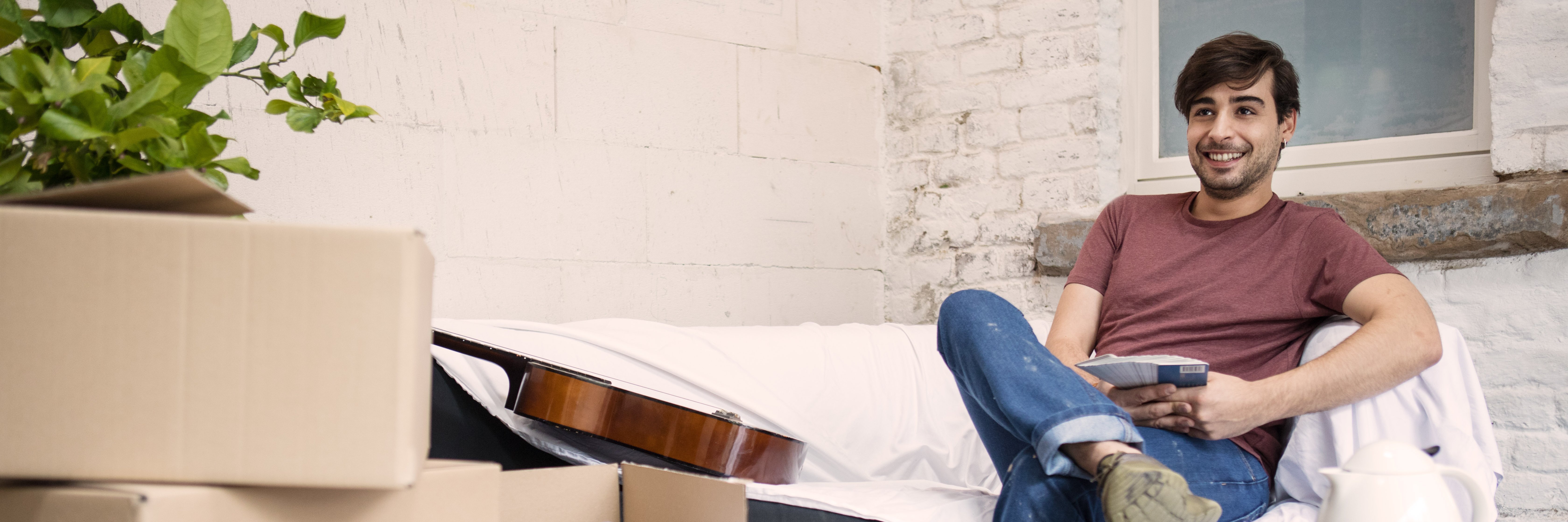 Muž sedí s úsmevom na gauči počas renovácie domu