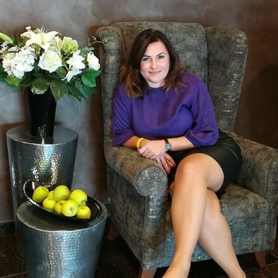 Žena v kresle vedľa kvetov