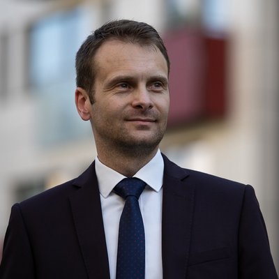 Muž v obleku na ulici s úsmevom