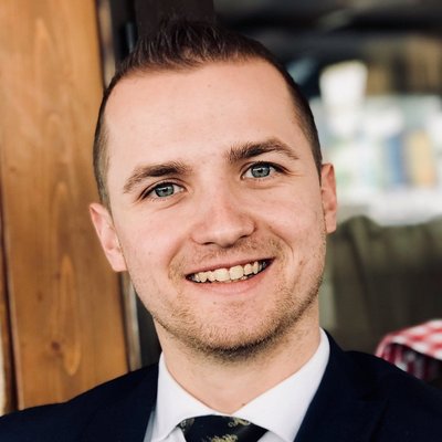 Muž s úsmevom v modrom obleku