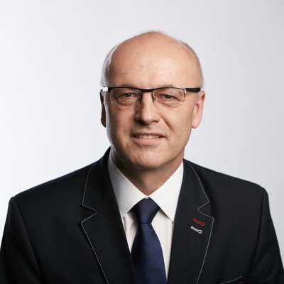 Starší muž s okuliarmi v obleku