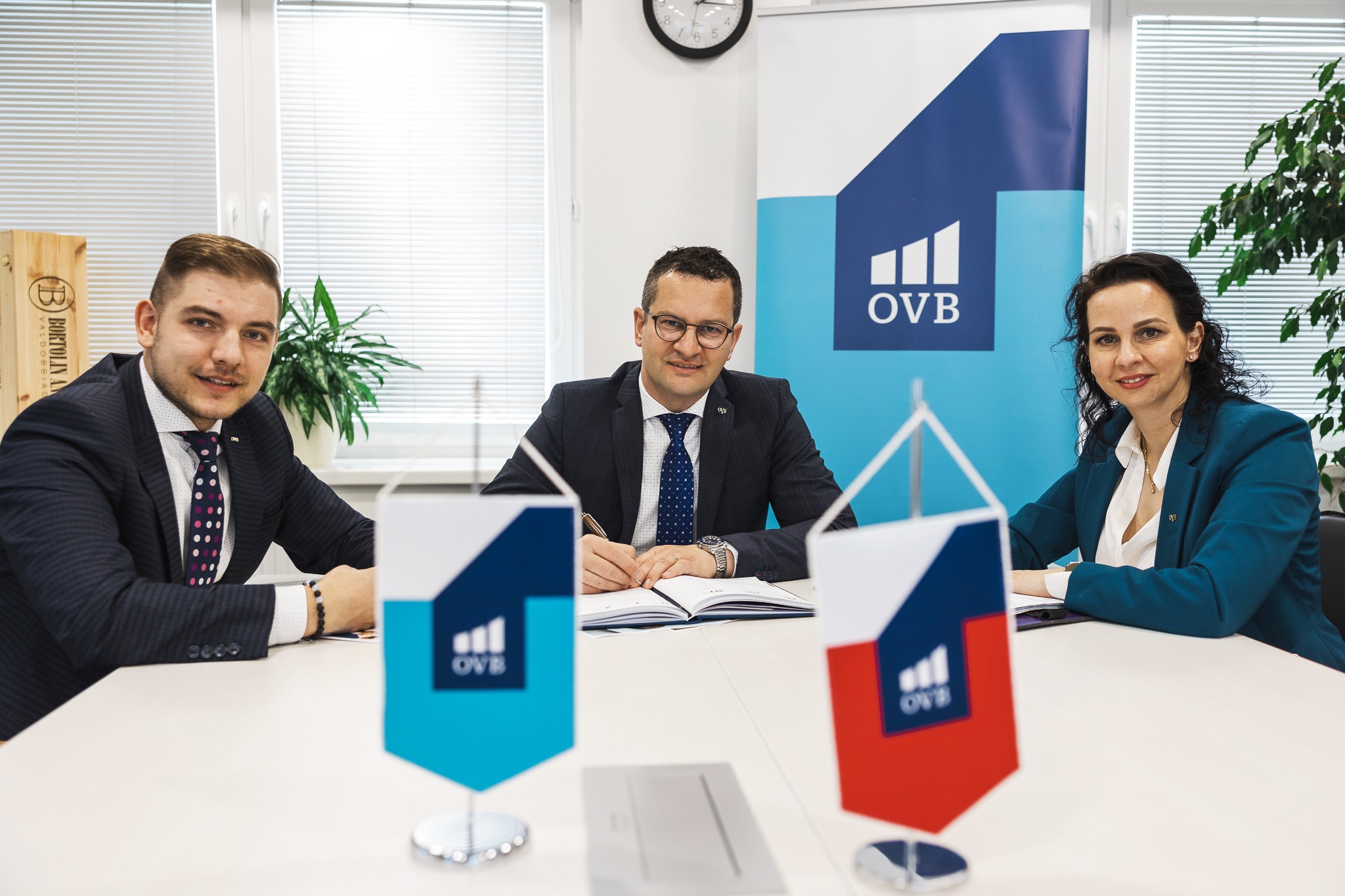 Traja kolegovia diskutujúci v kancelárii OVB