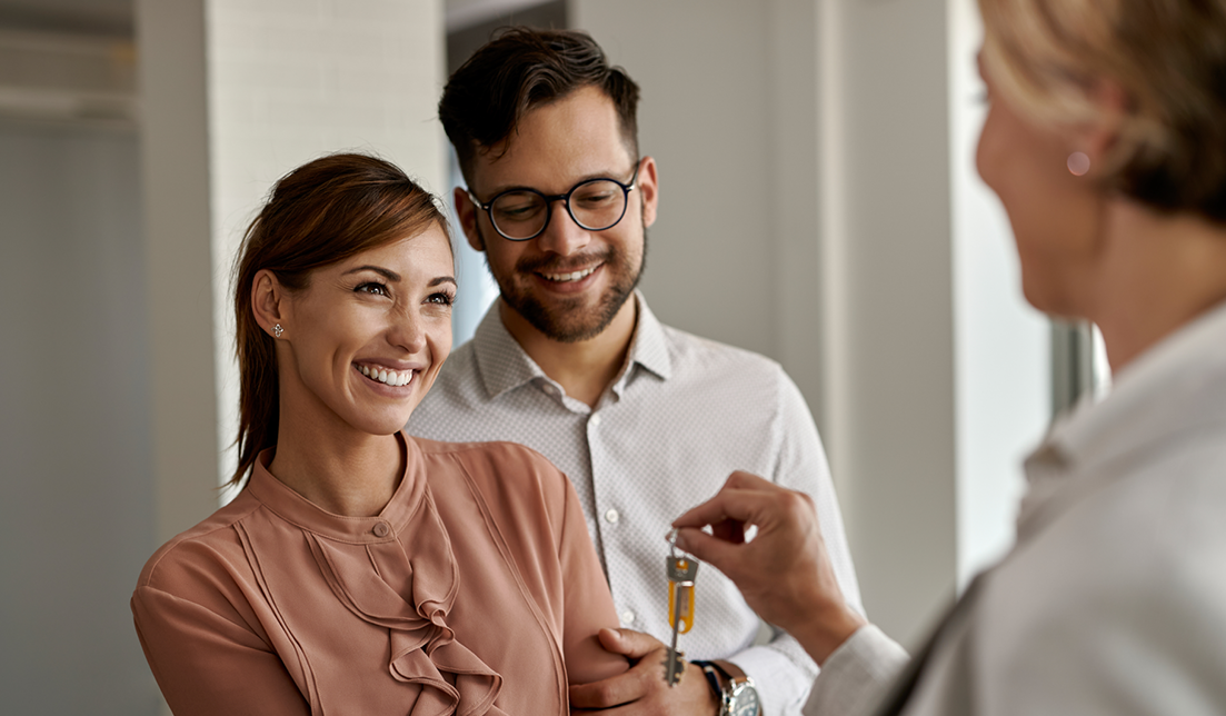 Usmiaty pár preberá kľúče od maklérky
