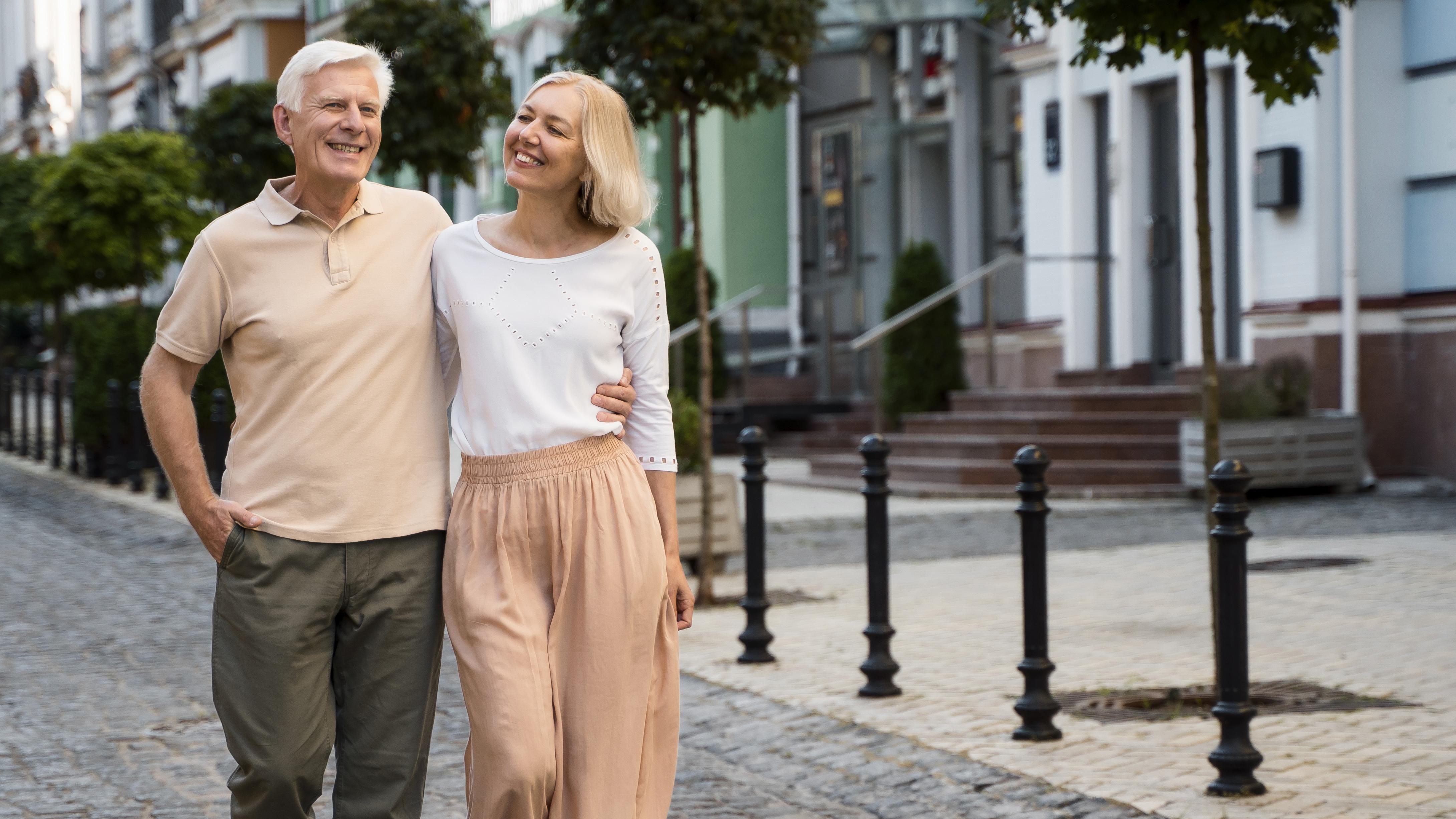 Starší pár sa prechádza mestom ruka v ruke