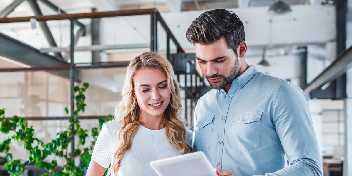 Muž a žena sledujú tablet v kancelárii