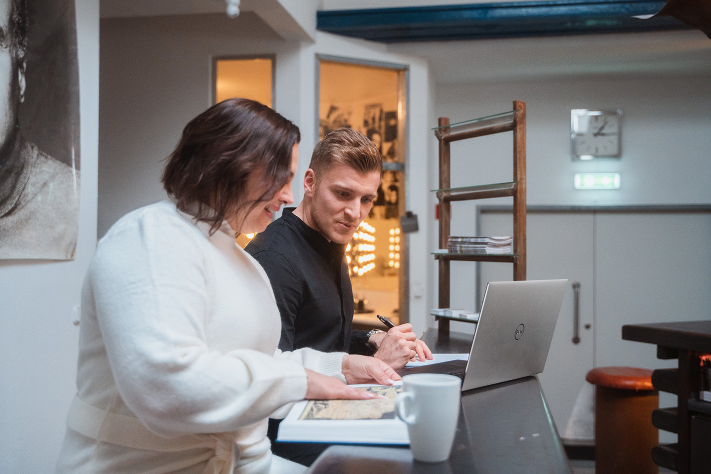 Kolegovia diskutujú nad dokumentom a notebookom