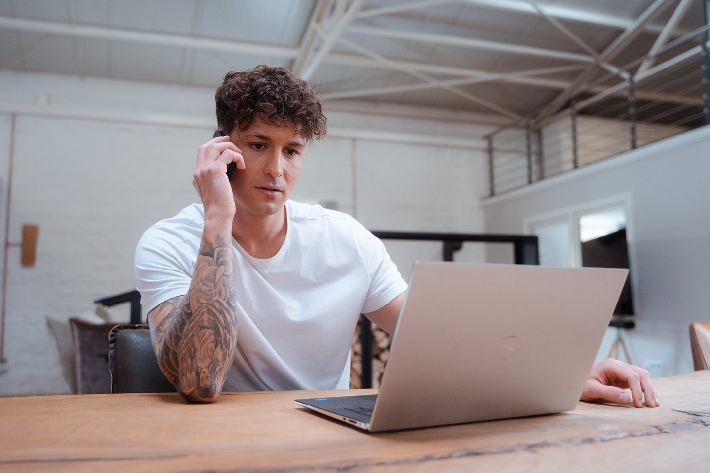 Muž telefonuje a pracuje na notebooku