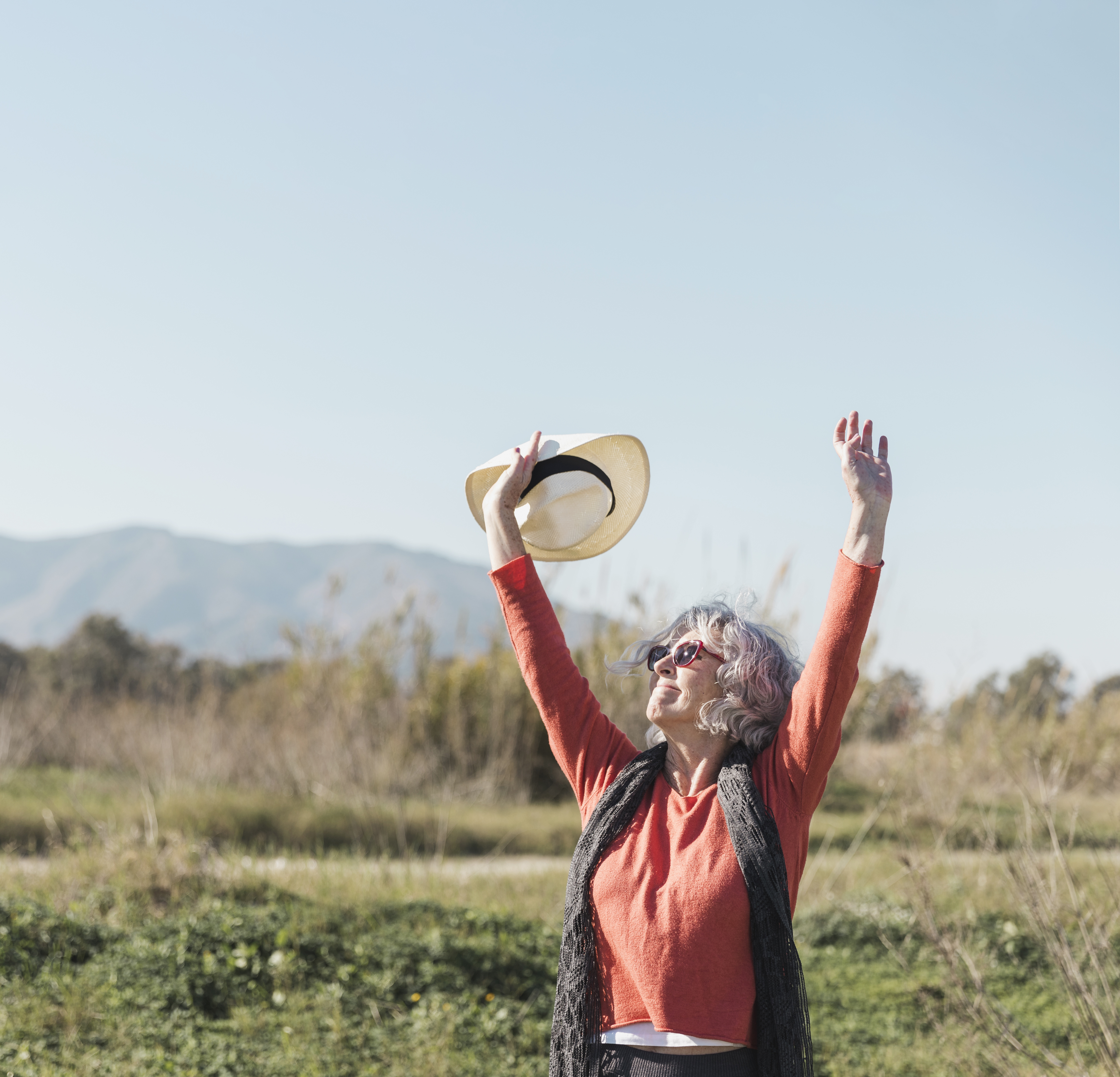 Šťastná dôchodkyňa s rukami nad hlavou