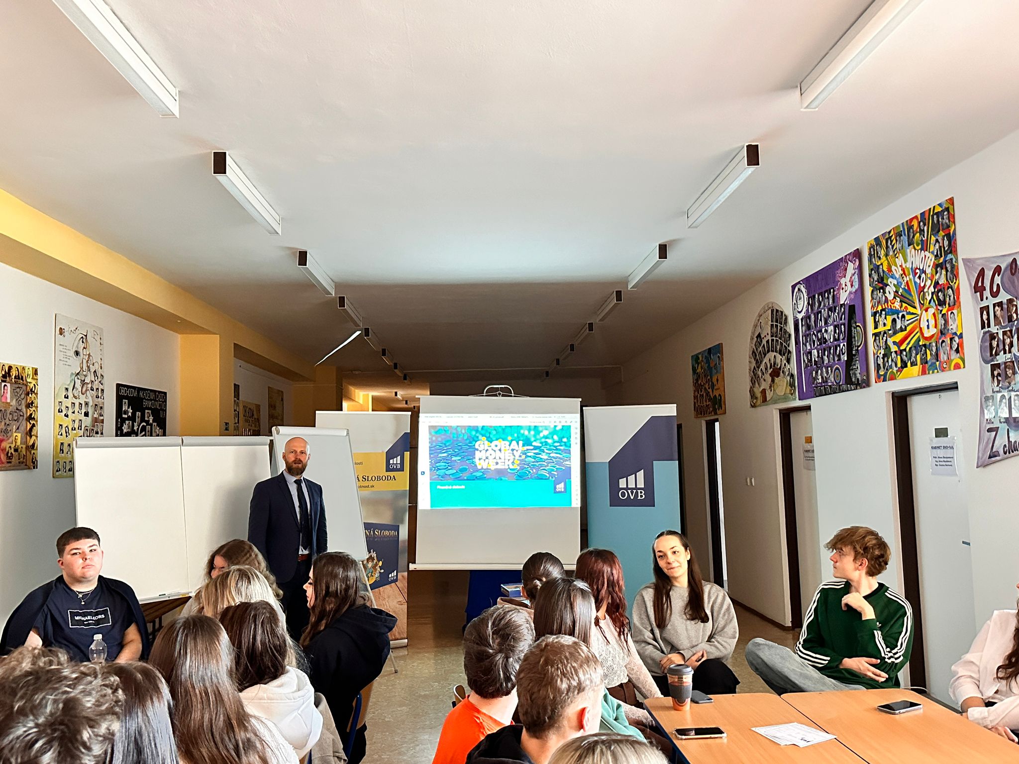 Lektor prednáša študentom o finančnej gramotnosti počas Global Money Week v triede