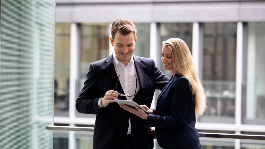 Muž a žena v business oblečení sa rozprávajú na chodbe v kancelárii