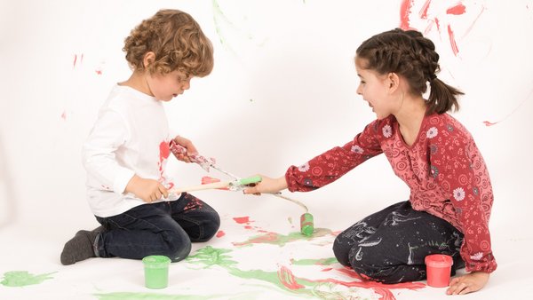 Dve deti sa hrajú a maľujú farbami